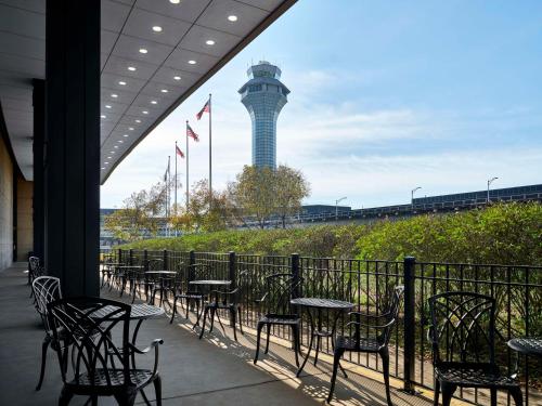 une rangée de tables et de chaises avec une tour de contrôle en arrière-plan dans l'établissement Hilton Chicago O'Hare Airport, à Rosemont