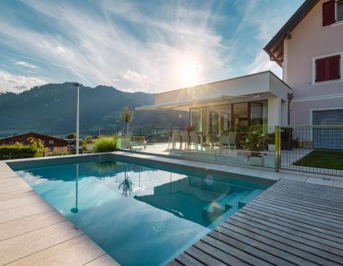 a villa with a swimming pool in front of a house at Freiraum 9 Living Apartment in Sankt Johann im Pongau