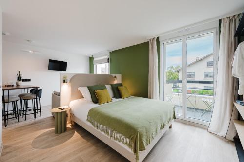 een slaapkamer met een bed en een groot raam bij Appart Hotel Neostelia in Annecy