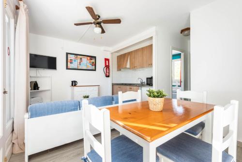 - une salle à manger et une cuisine avec une table et des chaises dans l'établissement Apartamentos Alta Galdana, à Cala Galdana