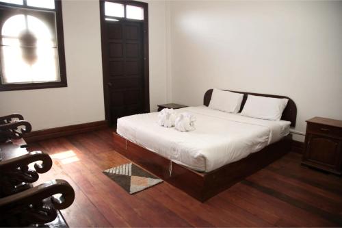 a bedroom with a bed with two towels on it at Villa KiengKham晶康民宿 in Luang Prabang