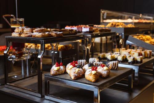 una exposición de pasteles y otros pasteles en una mesa en Hi Hotel - Wellness & Spa, en Trento