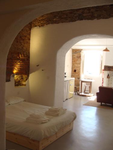 - une chambre avec un lit dans une pièce avec une arche dans l'établissement Casas Velhinhas - Apartº Aconchego e Apartº Calmaria, à Estremoz