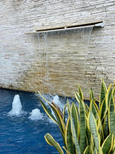 una fuente de agua al lado de un edificio en Mandai Apartamentos, en Cabo Frío