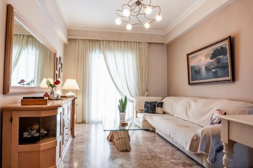 sala de estar con sofá y mesa de cristal en Cozy Cloud Apartment Nafplio, en Nauplia