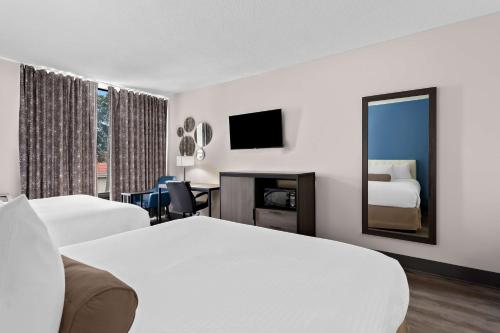 a hotel room with two beds and a mirror at SureStay Plus by Best Western Windsor in Windsor