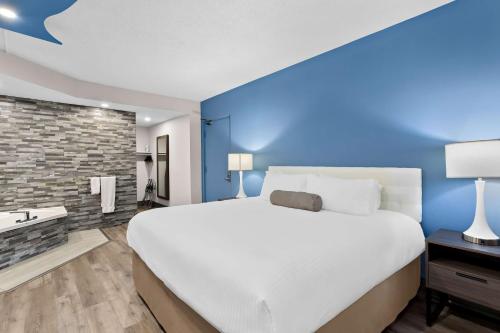 a bedroom with a large bed and a blue wall at SureStay Plus by Best Western Windsor in Windsor