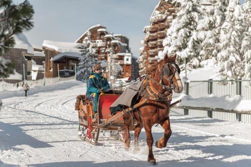 un hombre montando un trineo tirado por caballos en la nieve en Résidence Saskia Falaise - Avoriaz, en Avoriaz