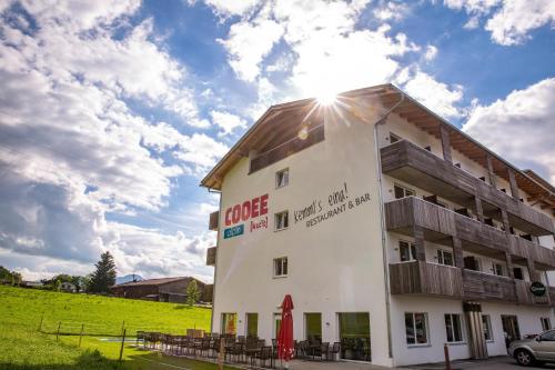 Biały budynek ze słońcem na niebie w obiekcie COOEE alpin Hotel Kitzbüheler Alpen w mieście Sankt Johann in Tirol