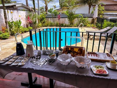 a table with food on it next to a pool at Résidence Le Tali in Libreville