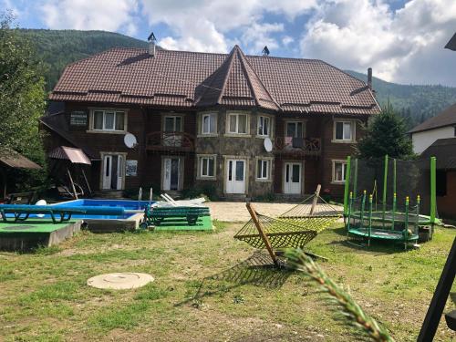 Cottage Zhelikhovskykh في تاتاريف: منزل كبير أمامه مسبح