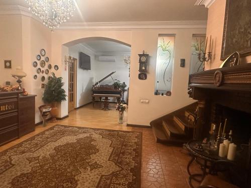 un ampio soggiorno con pianoforte e tappeto di Hin Yerevantsi Hotel a Yerevan