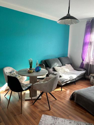 ein Wohnzimmer mit einem Sofa, einem Tisch und Stühlen in der Unterkunft Ferienwohnung HAPPYHOME Bahnhofnah gemütlich familiär in Arnstadt