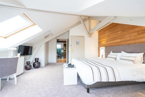 een slaapkamer met een groot bed en een televisie bij Hotel d'Angleterre in Châlons-en-Champagne