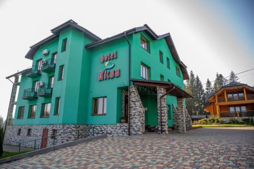 un gran edificio verde con una mazorca en Kisva Hotel, en Yablunytsya