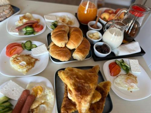 - une table avec des assiettes de produits pour le petit-déjeuner dans l'établissement SARVI Apartments, à Durrës