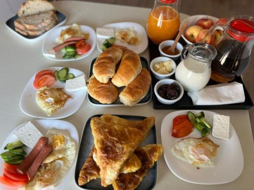 - une table avec des assiettes de produits pour le petit-déjeuner dans l'établissement SARVI Apartments, à Durrës