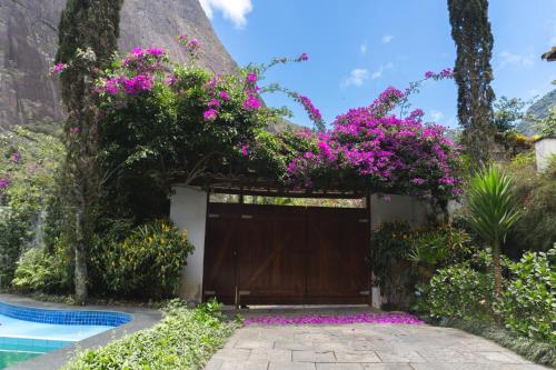 un garage avec des fleurs roses en haut dans l'établissement Chalé Rosa do Vale, à Petrópolis