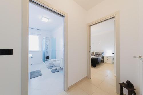 un baño con una puerta de cristal que conduce a un dormitorio en Swamyhome Aereoportobaripalese, en Bitonto