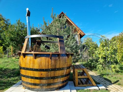 um barril de vinho de madeira sentado ao lado de um banco de madeira em Vila Stancevic wellness em Sremski Karlovci