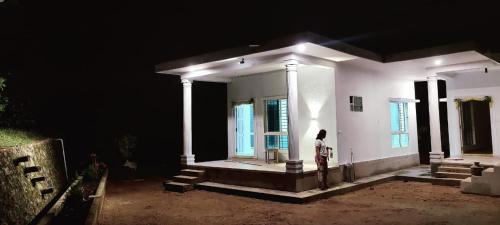 a person standing in front of a house at night at Malnad Bliss in Sringeri