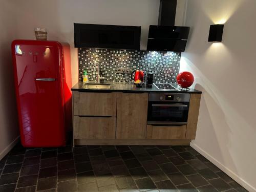 a kitchen with a red refrigerator in a room at OCV Infiny in Durbuy