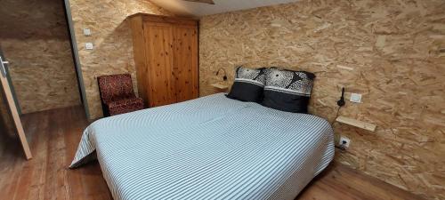 a bedroom with a bed in a stone wall at LE FIEF GUIBERT Hôtel particulier Maison d'hôtes et Gîtes in Le Poiré-sur-Vie