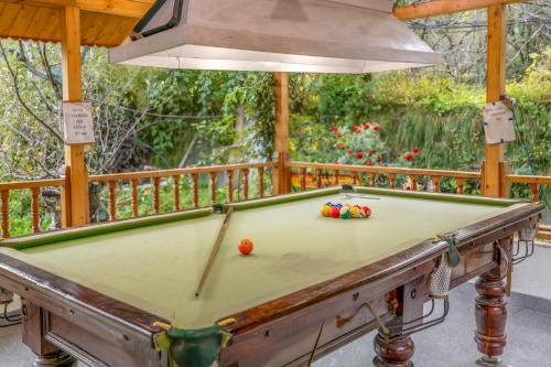 a pool table on a deck with awning at Hide-in Old Manali in Manāli