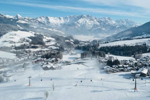 una stazione sciistica nella neve con montagne innevate di Hotel Krallerhof a Leogang