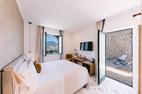 a bedroom with a white bed and a balcony at Palazzo Pascal in Scala