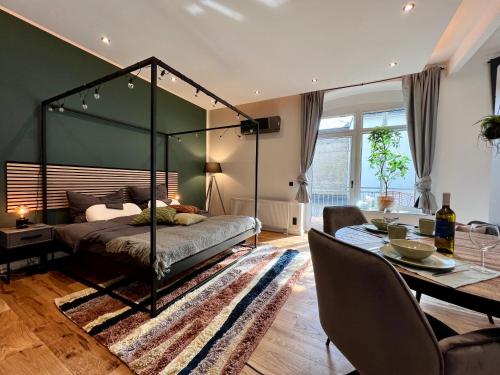 een slaapkamer met een hemelbed en een eetkamer bij EDLER WOHNRAUM Luxuriöses Studio im Zentrum mit Balkon, Kaffeevollautomat, Klima & Parkplatz in Zwickau