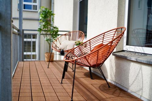 een paar stoelen op een balkon bij EDLER WOHNRAUM Luxuriöses Studio im Zentrum mit Balkon, Kaffeevollautomat, Klima & Parkplatz in Zwickau