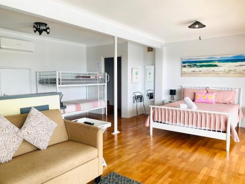 een woonkamer met een bed en een bank bij Citadel Suite in Port Macquarie