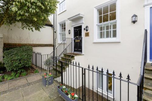 una casa bianca con una recinzione in ferro battuto di Elegant Epsom Flat in Period Building a Epsom