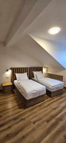 two beds in a large room with wooden floors at Hotel Karlova Prague in Prague