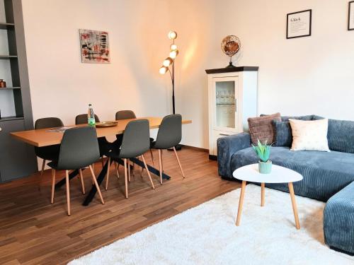 ein Wohnzimmer mit einem blauen Sofa und einem Tisch in der Unterkunft Ferienwohnung Gemütliche Auszeit - Wallbox, nur 50m zum Hauptbahnhof, ruhig, Parterre, zentral, Hunde willkommen, Kinderausstattung vorhanden in Gotha