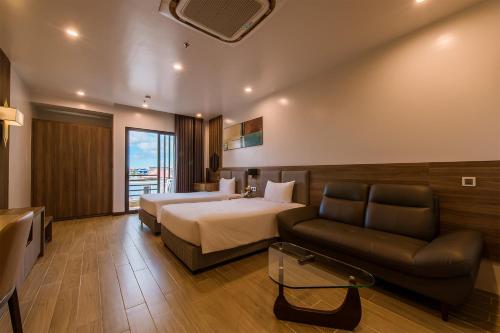 um quarto de hotel com uma cama e um sofá em ZEN RIVERSIDE HOTEL & RESIDENCES em Hai Phong