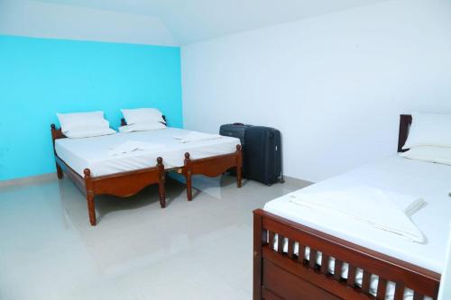 een kamer met 2 bedden en een koffer bij Jasmin Villa in Cochin