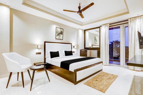 Super Townhouse Oak Udyog Vihar في جورجاون: غرفة نوم بسرير وكرسي ونافذة