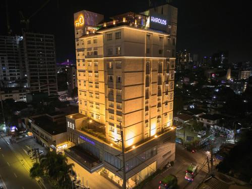 ein hohes Gebäude mit Lichtern in der Nacht in der Unterkunft Harolds Evotel Cebu in Cebu City