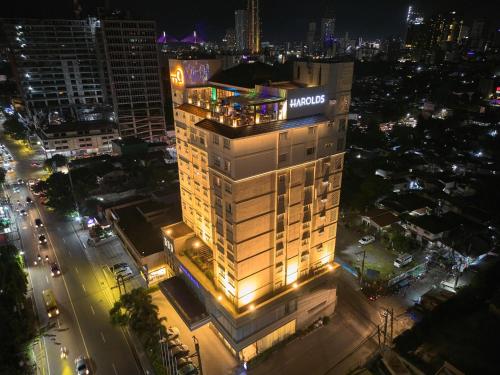 ein beleuchtetes Gebäude in einer Stadt in der Nacht in der Unterkunft Harolds Evotel Cebu in Cebu City