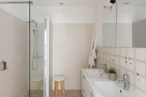 a white bathroom with a sink and a shower at Domaine Bocca di Feno in Bonifacio