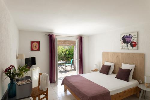 a bedroom with a large bed and a balcony at Domaine Bocca di Feno in Bonifacio