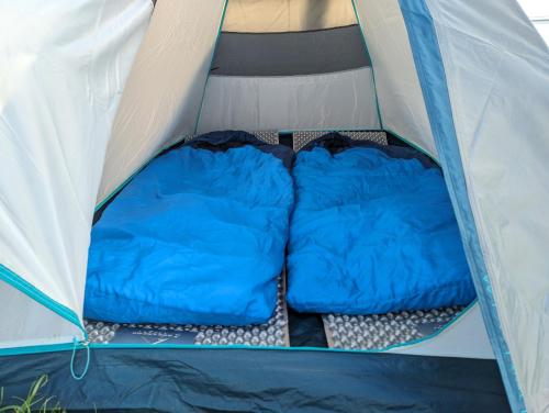 a blue and white tent with two sleeping bags inside at Camping Güino in Puerto Natales