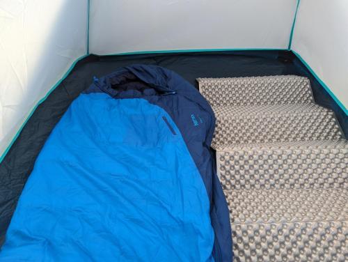 an open tent with a blue sleeping bag in it at Camping Güino in Puerto Natales