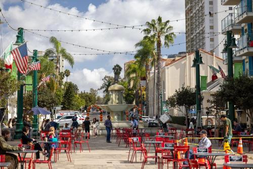 eine Straße mit roten Stühlen, Tischen und einem Brunnen in der Unterkunft Kasa Little Italy San Diego in San Diego