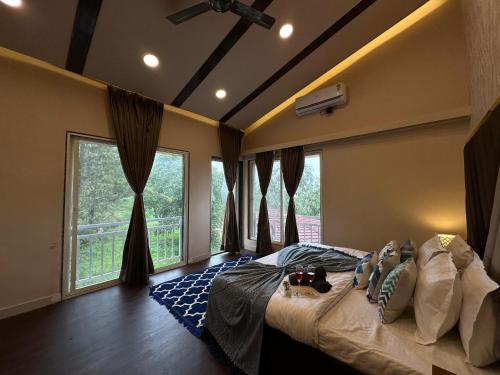 un cane che giace su un letto in una camera da letto con finestra di Lifeline Villas - Skyy High Luxurious Villa With Table Land & Valley View Villa a Panchgani