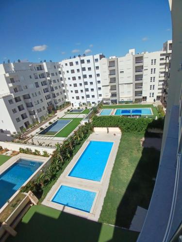 Cette suite offre une vue sur un grand complexe d'appartements doté de piscines. dans l'établissement Super loft B51, à Hammamet