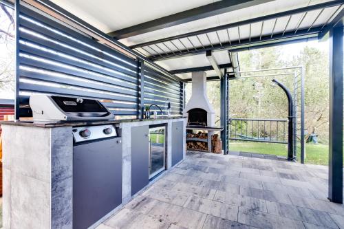 an outdoor kitchen with a stove and a fireplace at Relax house MAROKIS in Karlovac