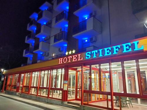 un hotel con una señal de hotel frente a un edificio en Hotel Stiefel, en Lignano Sabbiadoro